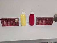 Overall lot showing two squeeze bottles and two boxed sets of glass shakers