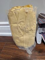 Sealed pack containing multiple yellow leather gloves