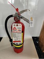 Front view of red ADV-550 fire extinguisher with tag and hose