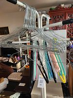 Overall view of clothes stand loaded with wire and plastic hangers