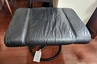 Top view of black leather footrest on swivel base