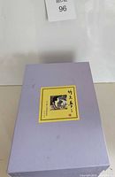 Closed lavender cardboard box with Japanese graphic label