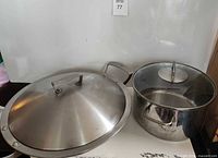 Zwilling wok with lid next to WMF pot with lid