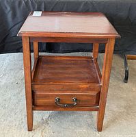 Front view of wooden accent table showing drawer and shelf