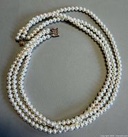 Entire triple-strand pearl necklace coiled