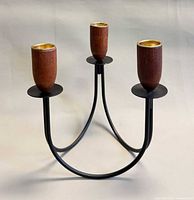 front view showing three iron arms, teak candle cups, overall form
