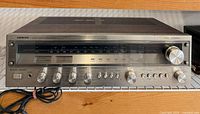 Front angled view of receiver showing faceplate, knobs, wood cabinet, power cord
