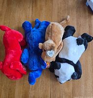 Top view of four Ty Beanie Babies lying side by side showing overall colors and forms