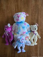 Front view of all four Ty bears on wood surface