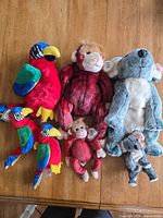 Overview of all seven plush toys laid out on table