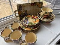 Dinnerware set stacked showing plates, bowls, mugs, platter