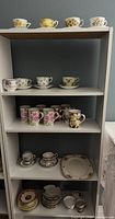 Full shelf view showing multiple cups, saucers, mugs and platter