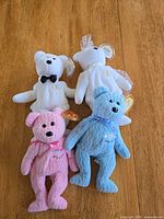 Front view of four bears showing tags and accessories