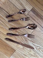Five-piece place setting showing rose gold finish on spoon, fork, knife