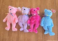 front view of four Ty Sherbet bears in pink, lavender, fuchsia, blue