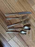 Knife, two forks, two spoons showing gold accent pattern