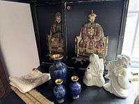 Overall shot of both framed art pieces, three blue vases, two white figurines