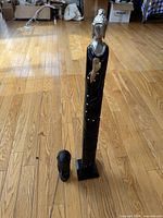 Tall robed wooden statue and smaller head statue shown together on wood floor