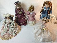 All five porcelain dolls and plush rabbit displayed