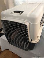 Front angled view showing plastic body, metal wire door and side vent