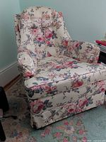 Front view of cream and pink rose floral skirted wingback chair