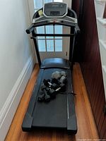 Full view of treadmill with dumbbells on deck