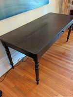 Full view of dark brown wooden table, top and legs visible