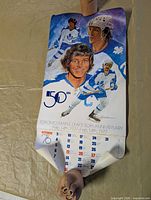 Full view of calendar showing player artwork, 50th graphic and bottom page curl