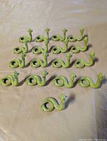 All 17 green snake figurines arranged in rows
