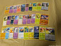 All 30 Pokémon cards laid out in three rows on table