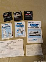 Three game cartridges and three manuals displayed on table