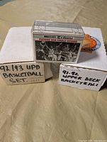 Three boxed sets: two Upper Deck boxes and one clear Hoops case