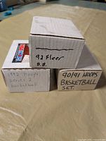 Three labeled card set boxes stacked showing years and brands