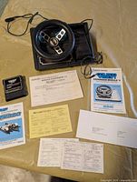 Steering wheel controller, Turbo cartridge, manuals and paperwork laid out on table