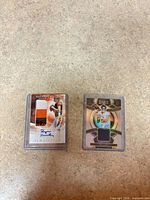 Both trading cards in cases: Finley Origins RPA and Levis Select relic