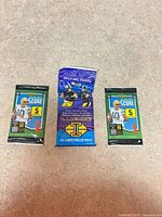 Overview showing three sealed NFL trading card packs: two Panini Score, one Panini Illusions