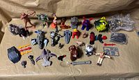 Full layout of assorted figures, vehicles, parts and accessories on beige surface