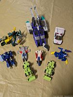 Group shot displaying all nine Transformer figures arranged on surface