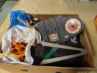 Contents of lot: multiple black track segments, lap counter with dial, guardrails, risers, metal braces in box