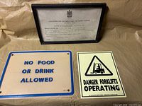 Overview of all three items: framed certificate, no food sign, danger forklifts sign
