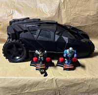Batman Tumbler vehicle with two action figures on bases in front