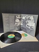 Gatefold open with one record partially outside, shows inner artwork and label design