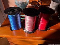 Blue, pink and red ribbon spools grouped