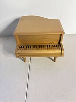 closed gold piano-shape box front view