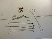 Entire lot laid out showing vine bracelet, chain pieces, brooch, earrings