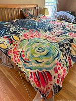 Comforter spread on bed showing full floral pattern and throw pillow