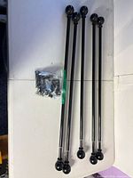 Five black curtain rods with bag of hardware