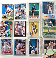Group of sleeved baseball cards featuring various players such as Roberto Alomar, Joe Carter, Dave Stewart