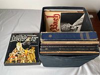 Crate filled with records and separate stack of LPs