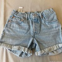 Front view of Levi's light-wash denim shorts with rolled cuffs